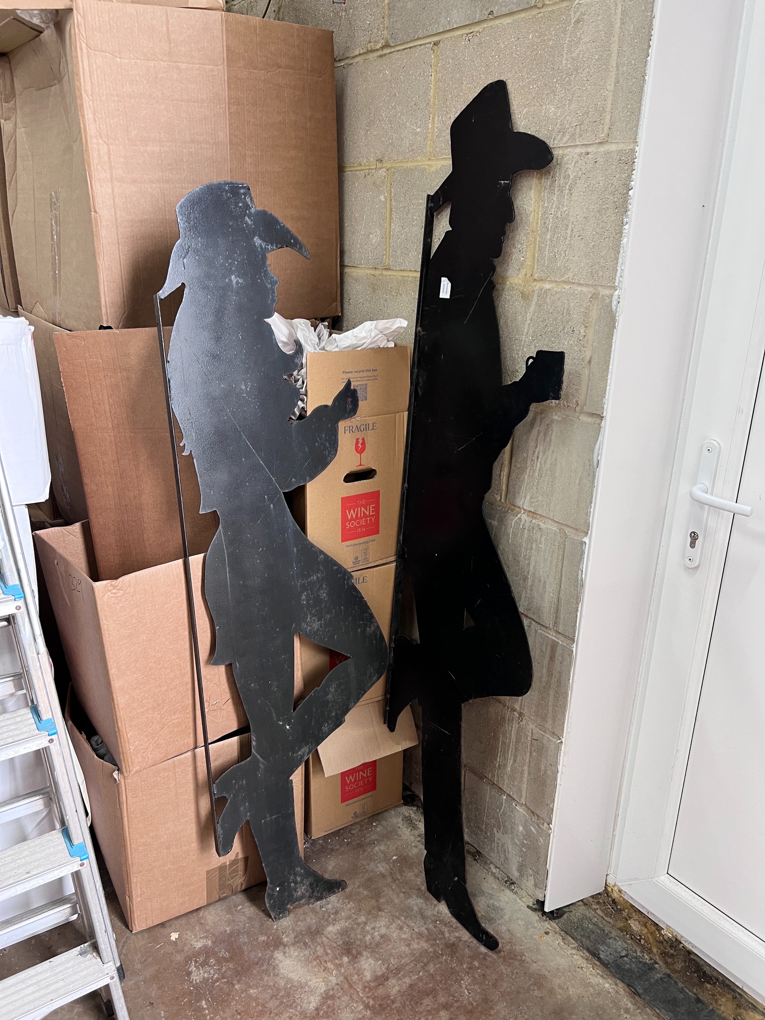 A pair of black painted iron silhouettes of cowboys, largest 177cm *Please note the sale commences at 9am.